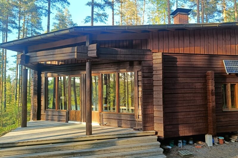 Valmiiksi pinnoitettu hirsihuvila Somerolla auringonpaisteessa.