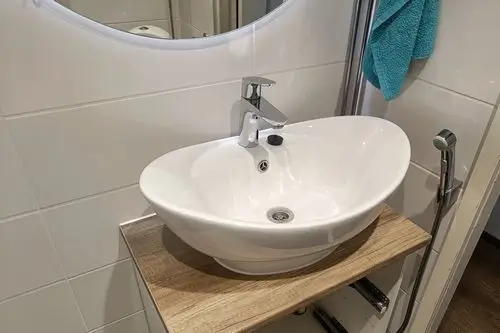 Valkoinen kulhomainen allas asennettuna kylpyhuoneessa Turussa.