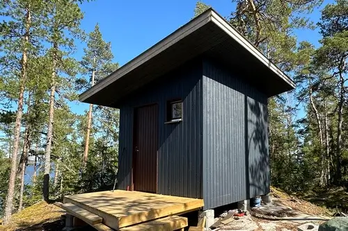 Kallion päälle rakennettu sininen vierasmökki Naantalissa.